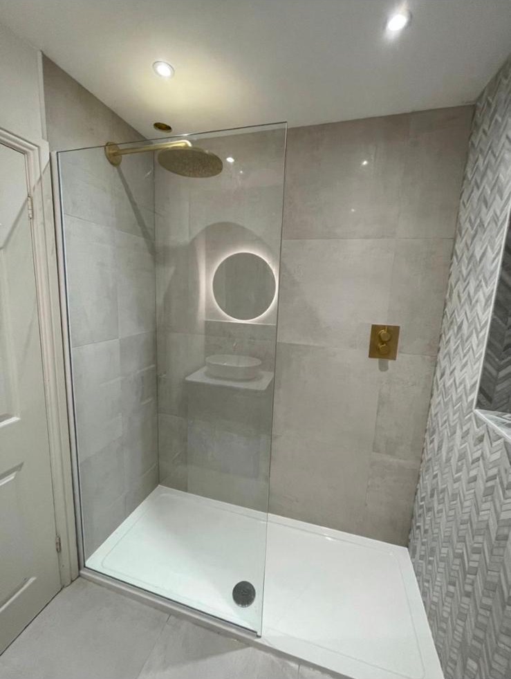 Walk-in shower with brushed brass fittings, one of Daniel's completed en-suites