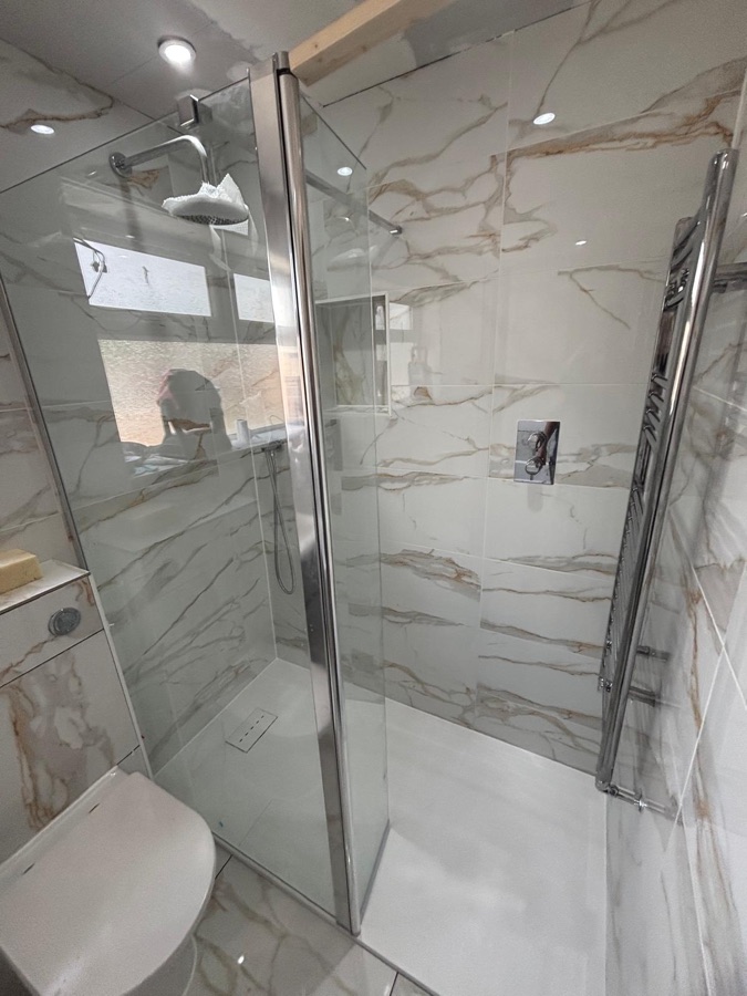 Calacatta gold marble-effect tiles in a walk-in shower